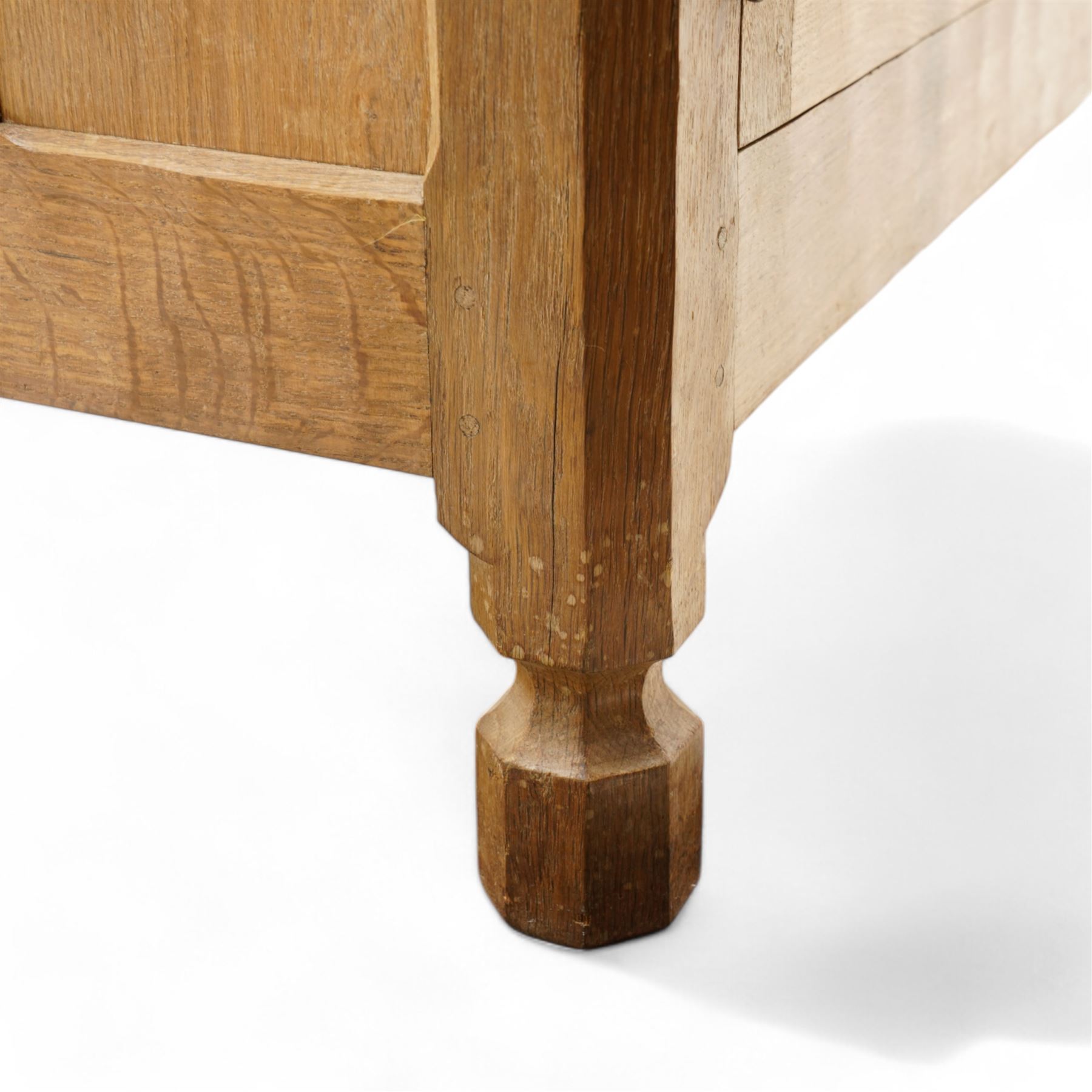 Mouseman - adzed and panelled oak 6' sideboard, fitted with four central drawers and flanking cupboards, enclosed by two panelled doors with wrought metal latches and hinges, on octagonal feet, carved with mouse signature, panelled sides, by the workshop of Robert Thompson, Kilburn 