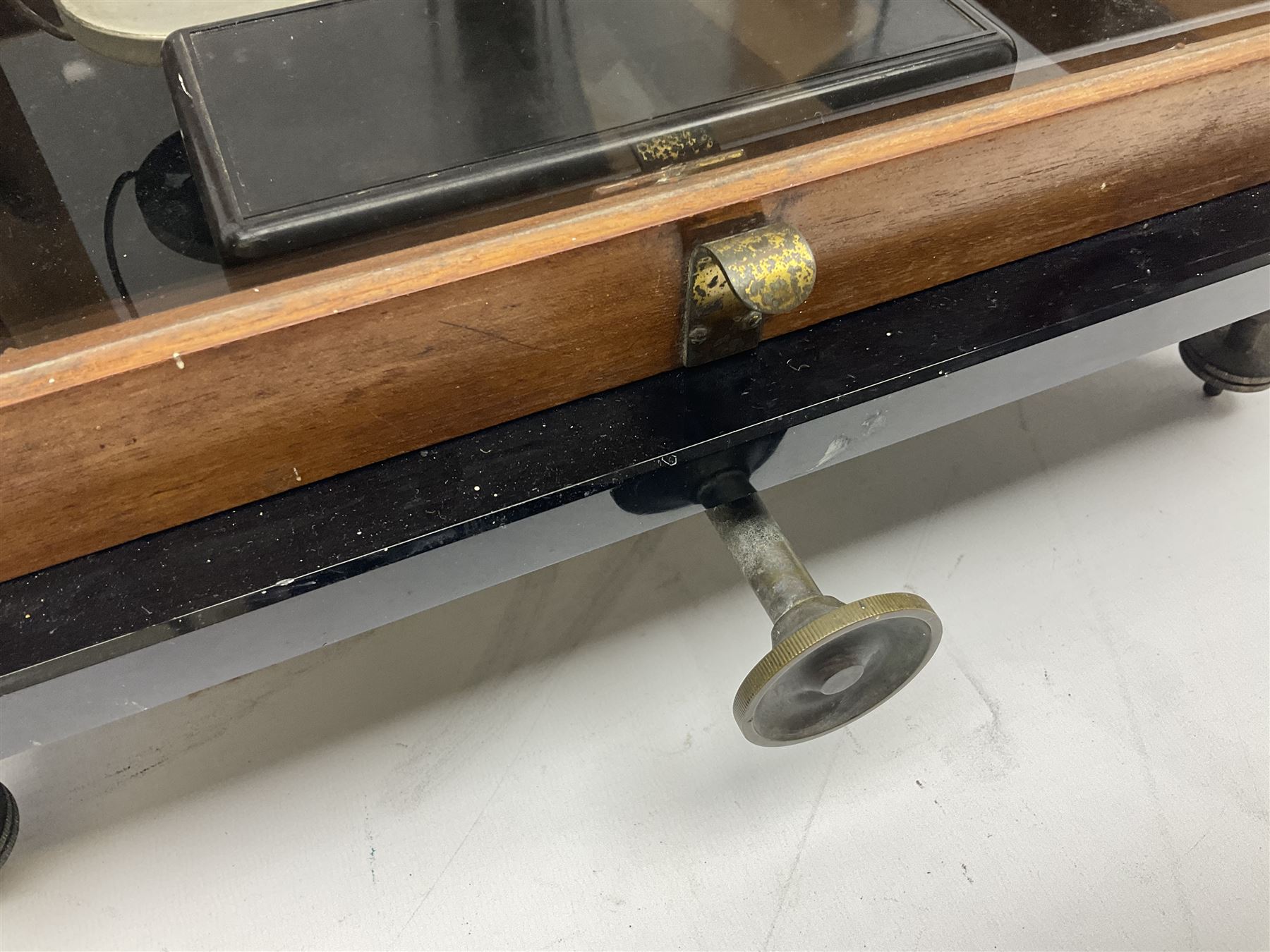 Set of laboratory balance scales by Reynolds & Branson of Leeds in fully glazed mahogany case with rise-and-fall front door, black vitrolite base with brass feet and hand cranked action L40cm H51.5cm D30cm; and bakelite cased set of brass weights