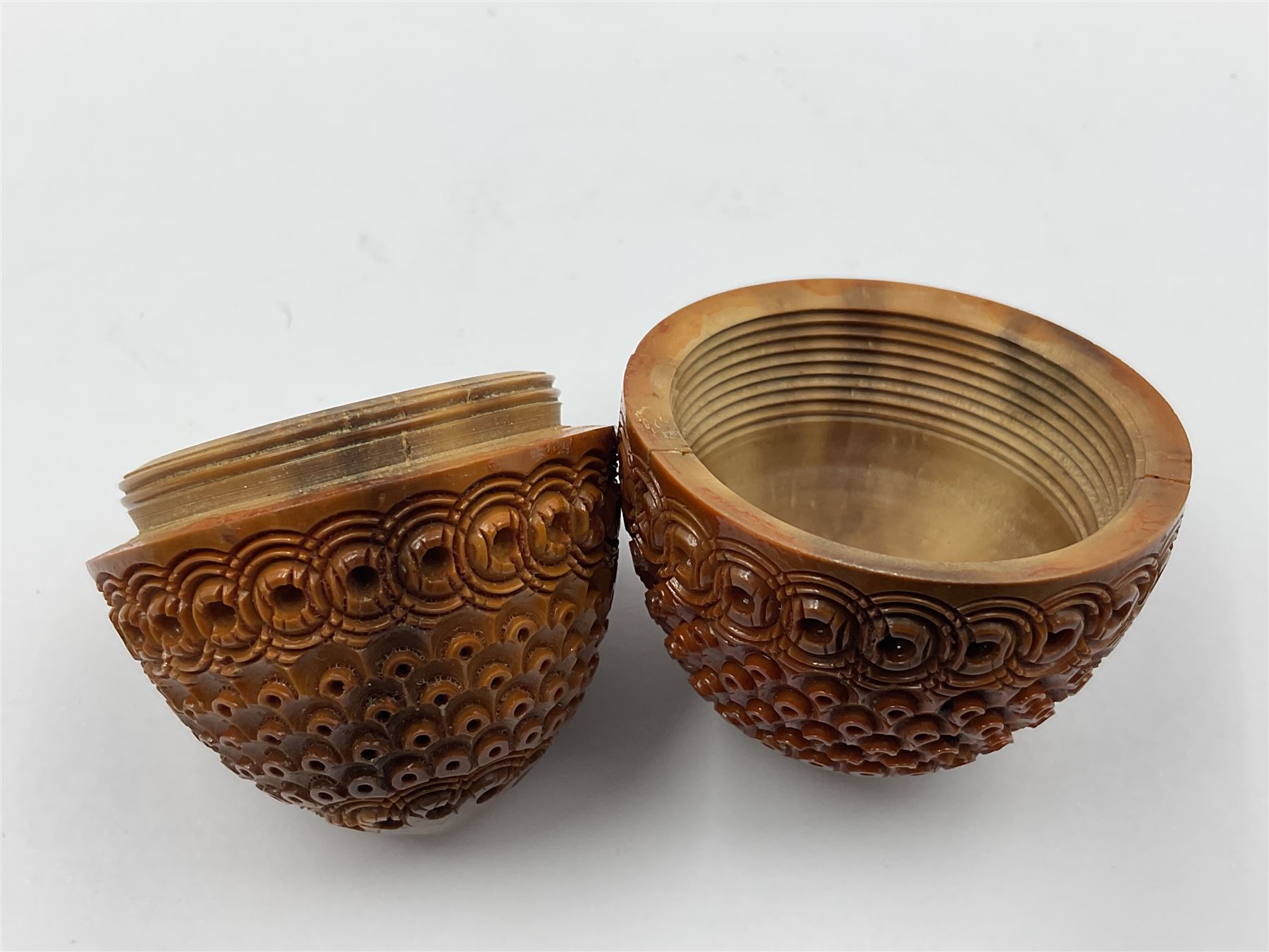 Three 19th century coquilla nut pomanders or flea catchers, two of egg shaped form and the third of barrel from with carved and pierced decoration and screw threaded join, largest H8cm