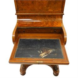 Victorian burr walnut piano-top Davenport, the raised rectangular superstructure with moulded cornice above a panelled fall-front enclosing drawers, the curved hinged writing slope opening to reveal a fitted interior above a sliding tooled leather writing surface, flanked by carved foliate scroll supports, the right side fitted with four drawers behind an arched panelled cupboard door with brass inset campaign-style handles, on a shaped plinth base and bun feet