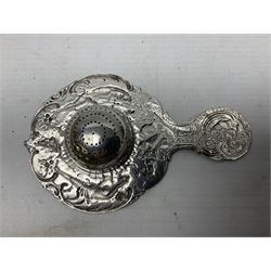 Continental white metal strainer, of shaped form embossed with classical figures, putto, musical trophies and fruiting vines, indistinctly marked, L12.5cm