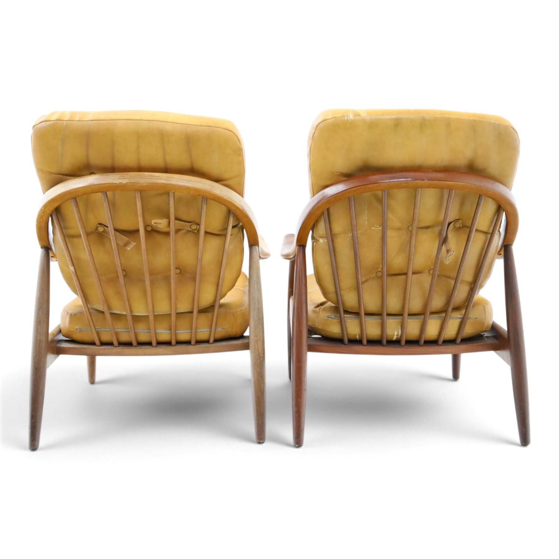 Greaves & Thomas - pair of mid-20th century light elm framed lounge armchairs, with downswept arms and a spindle back, webbing base with makers mark, tan brown leather seat cushions with button back detail