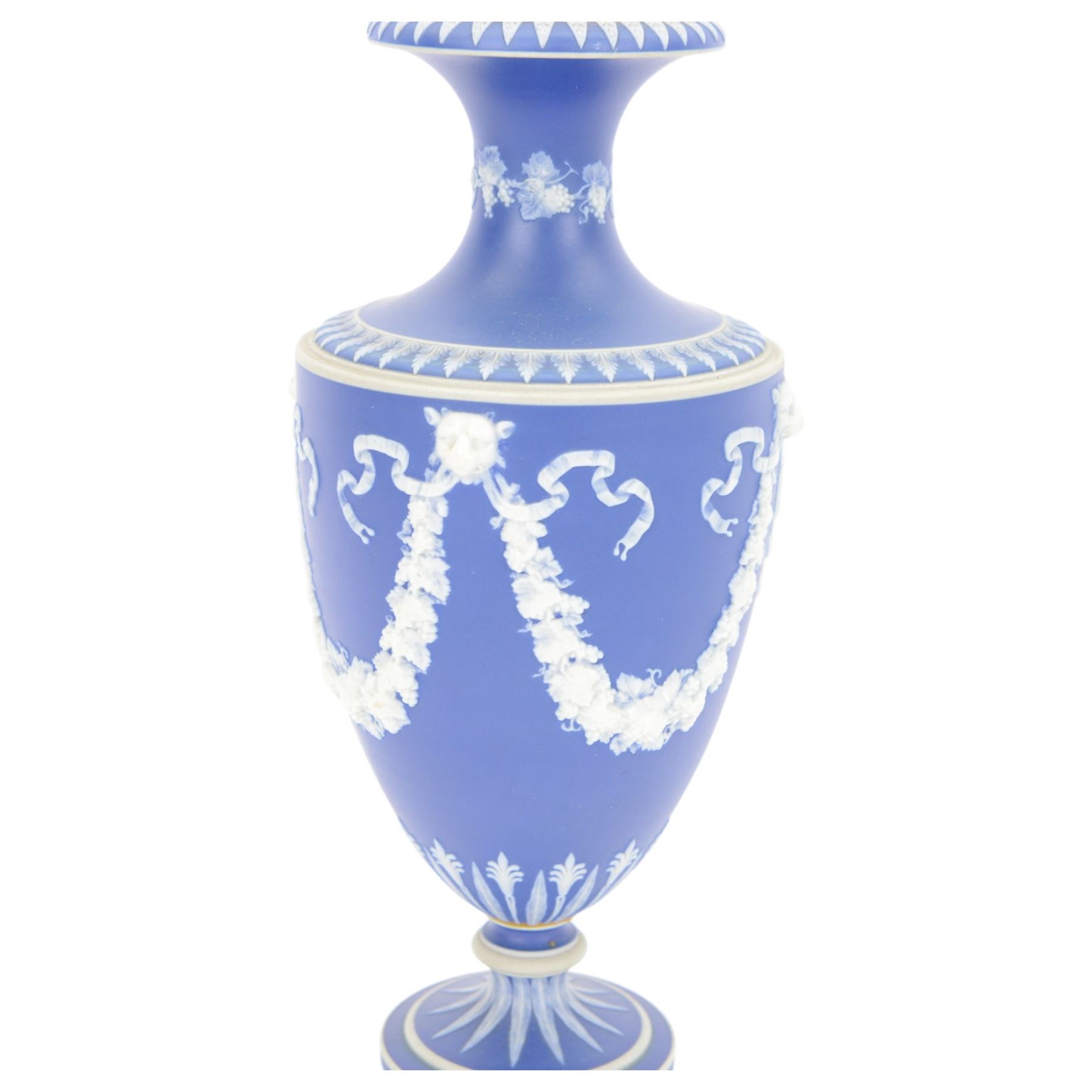 Early 20th century Wedgwood Jasperware vase, of baluster form with fluted rim, decorated with floral swags united by goat masks on a dark blue ground, together with a pair of Wedgwood jasperware spill vases, tallest H24cm