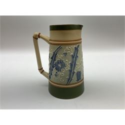 James Macintyre 'Gesso Faience' jug decorated with tubelined flowers and scrolling foliage in tones of blue against a pale green ground, printed mark beneath, H17cm