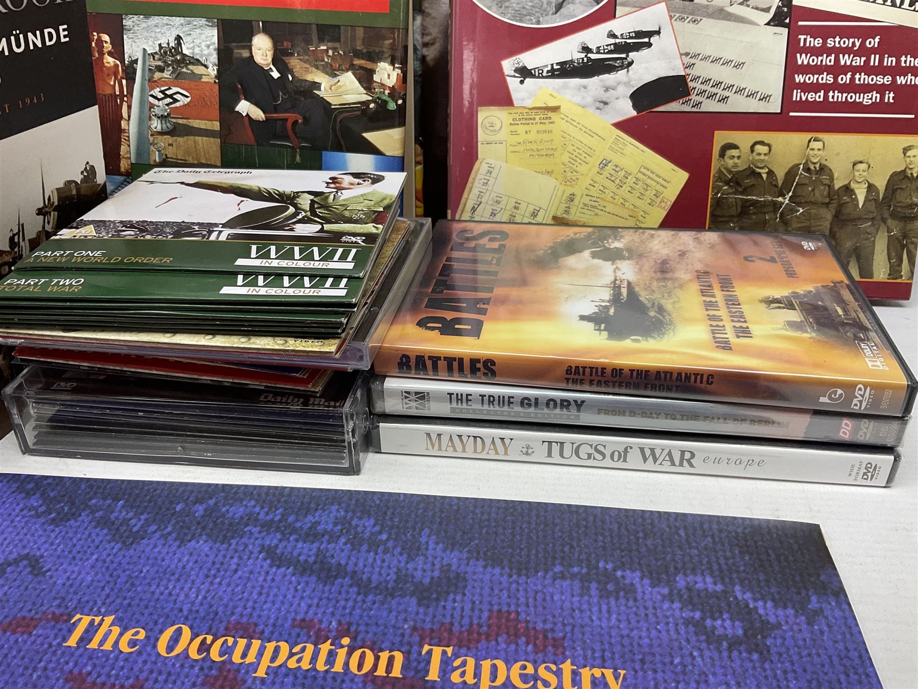 Thirty modern books of military interest including The Wartime Scrapbook 1939-1945; D-Day by Stephen Badsey; The D-Day Experience by Richard Holmes; Desert Rats by John Parker; A Most Secret Squadron by Des Curtis; Flying Colours - The Epic Story of Douglas Bader by Laddie Lucas etc; and quantity of DVDs of war and military interest