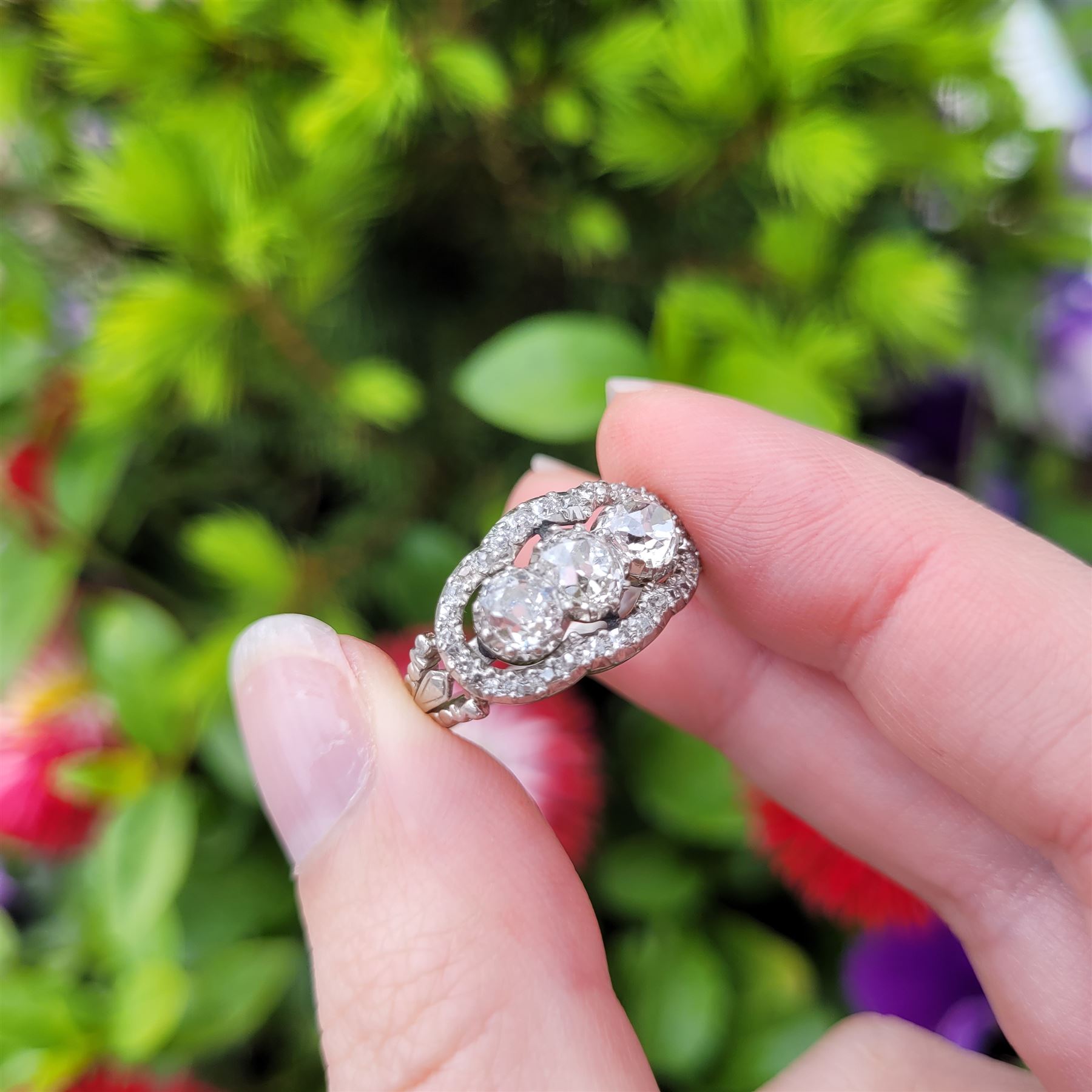Late 19th / early 20th century platinum diamond ring, three old cut diamonds, in an openwork setting surrounded by further old cut diamonds, with pierced design shoulders, principal three diamonds total weight approx 1.45 carat, in a velvet and silk lined box by Selfridges