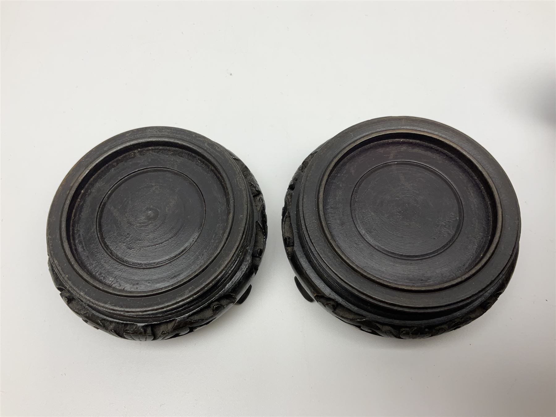 Pair of Chinese cinnabar lacquer vases, each of bulbous baluster form, carved with peonies and foo dogs amongst scrolls, with blue enamel interior and upon wooden bases, H20cm