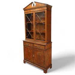 Georgian design Pollard -Oak bookcase cabinet over cupboard with panelled cupboards and two drawers, arched pediment above a dentil frieze and a pair of glazed doors enclosing adjustable shelves, raised on shaped bracket feet