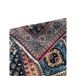 Persian Yalameh coral ground runner rug, the field decorated with seven hooked lozenge medallions surrounded by stylised plant motifs, the indigo spandrels decorated with similar patterns, guarded border with repeating diamond lozenges