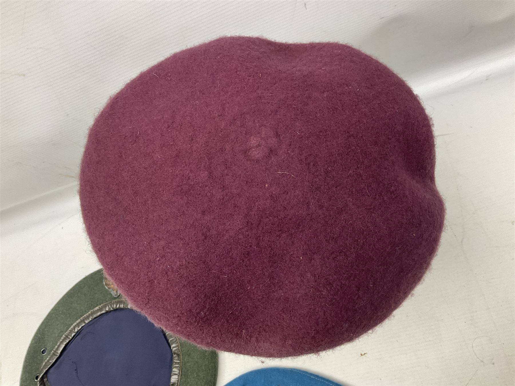 Four paratrooper berets - Russian, Italian, British and Foreign Legion; all with badges (4)