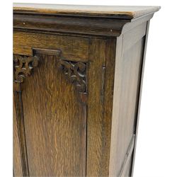 Early 20th century oak triple wardrobe, three panelled doors with geometric mouldings and fretwork spandrels, the interior fitted with slides and hanging rail