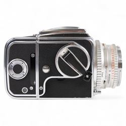 Hasselblad 500C medium format camera, serial no. TC60836, circa 1965, with Carl Zeiss Planar 1:2.8 f=80mm lens with cap, serial no. 4199654, one film back, serial no. TC87300 and a Hasselblad PM5 prism viewfinder serial no. 401EE1335