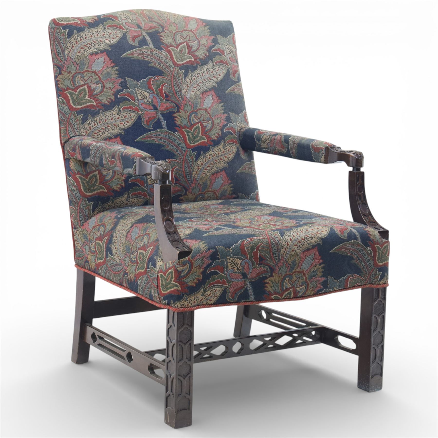 Early 20th century Chippendale revival Gainsborough elbow chair, rectangular upholstered back and seat covered in foliate patterned fabric, with open arms carved to the terminals and supports with pierced and geometric detail, raised on square section legs with blind fretwork panels