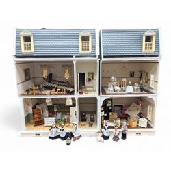 Two modern three storey dolls houses, each painted green with decorated interiors, both upon a single white wooden base, together with a large collection of dolls house furniture, accessories and figures 
