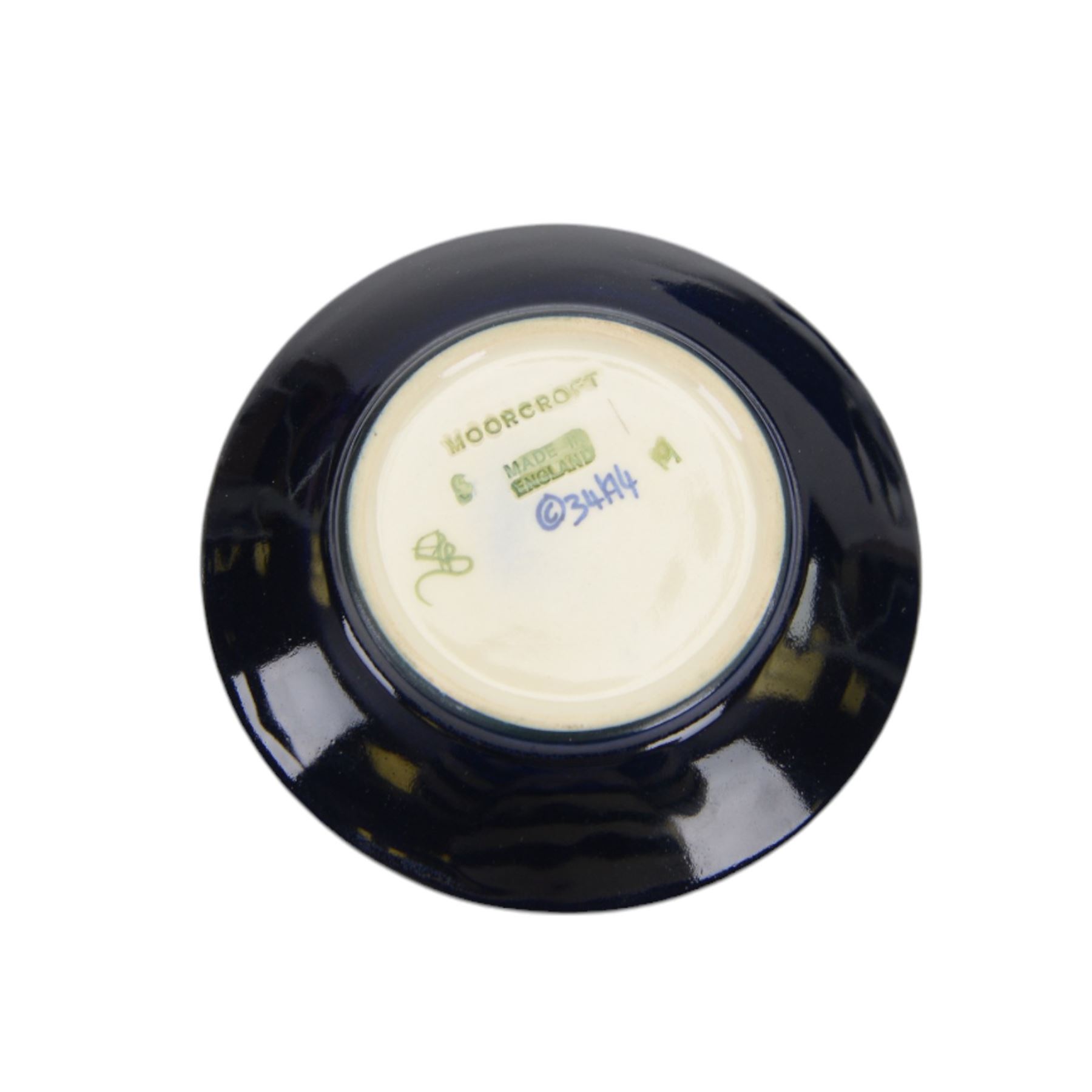 Two Moorcroft ashtrays in Magnolia pattern and Anemone pattern, together with pin dish in anemone pattern  