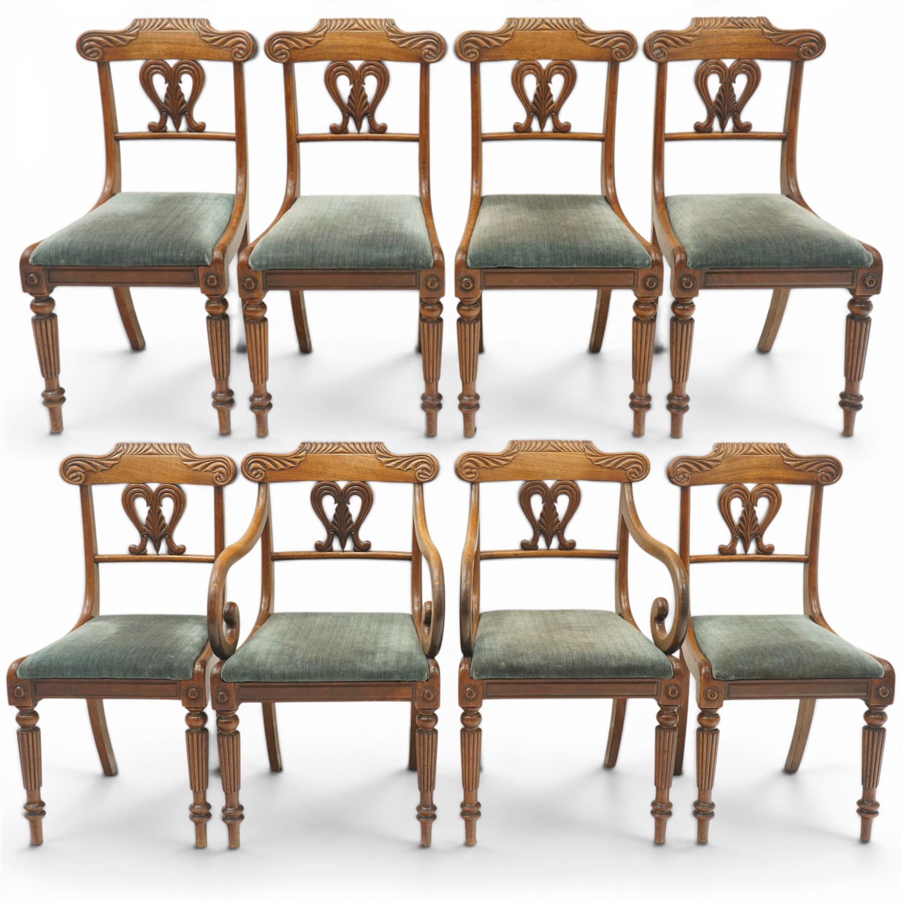 Set of eight (6+2) Regency period mahogany dining chairs, the ornately carved cresting rail of gadrooned and foliate design, over a pierced swan-neck splat with scrolling foliate carving, the carvers with scrolled arm terminals, over teal-upholstered drop-in seats, raised on Gillows-design reeded and tapering front supports, retailed by David Hick Interiors, Jersey