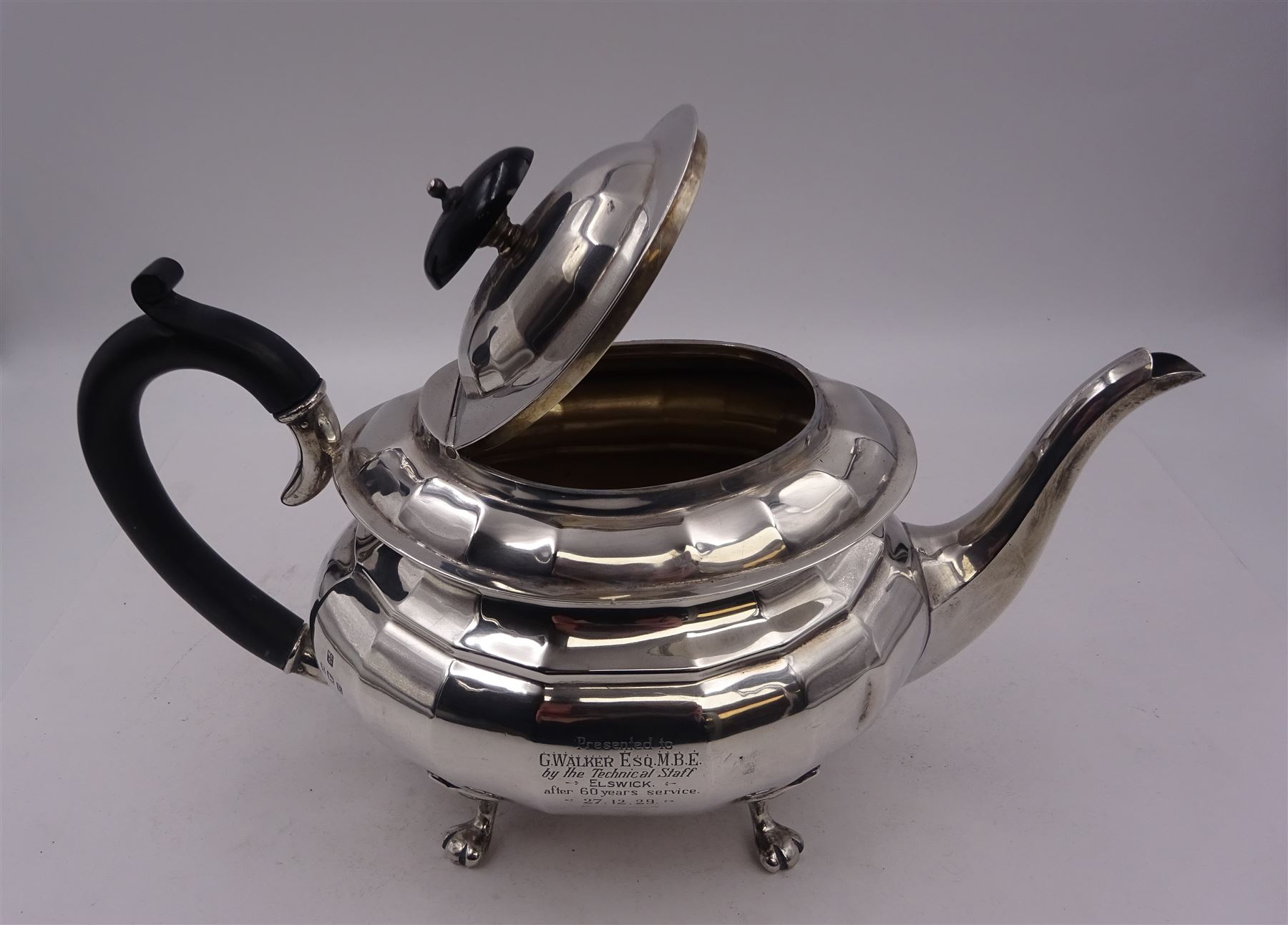 1920s silver teapot, of oval faceted form, with Bakelite type handle and finial, with presentation engraving to body, and upon four paw feet, hallmarked Northern Goldsmiths Co, Birmingham 1929, H16cm