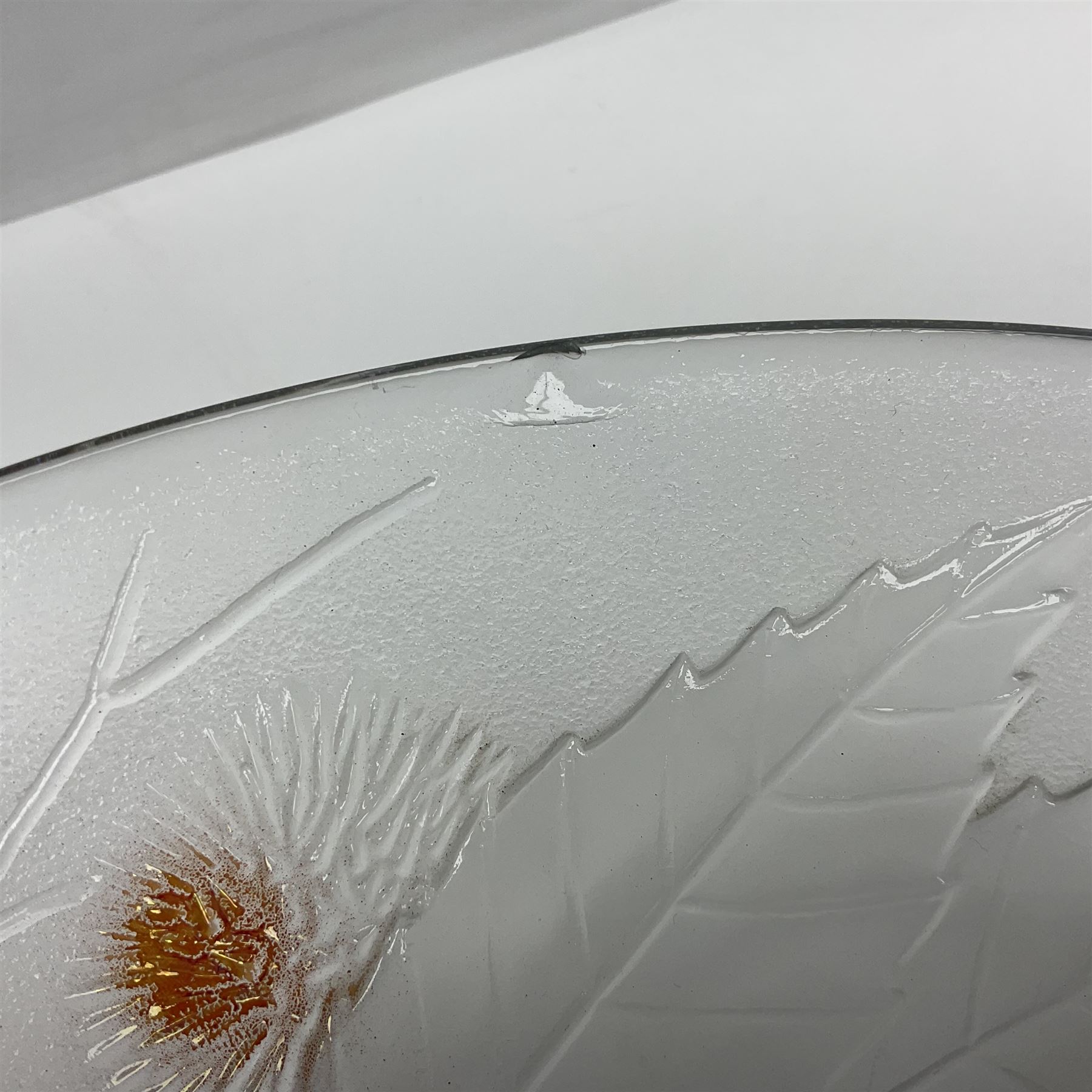 Two French pressed glass bowls of shallow circular form, relief moulded with flowers and foliage, together with a matching charger, largest bowl D34cm  