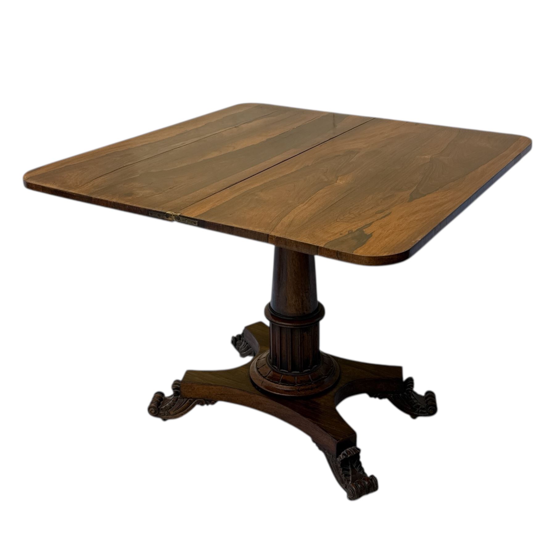 William IV rosewood card table, rounded rectangular swivel and fold-over top with plain frieze, with carved scrolled brackets above stop-fluted column with moulded collar on quadriform base with scrolled feet 