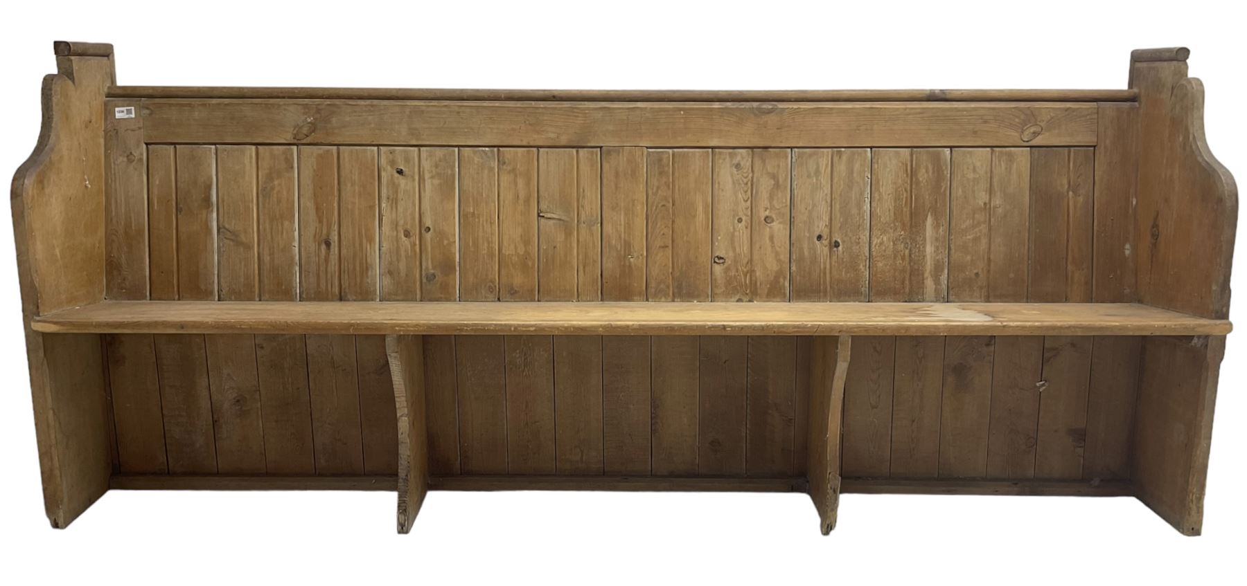 Early 20th century pine church pew, vertical plank back over rectangular seat, flanked by shaped end supports, with bible rest to back