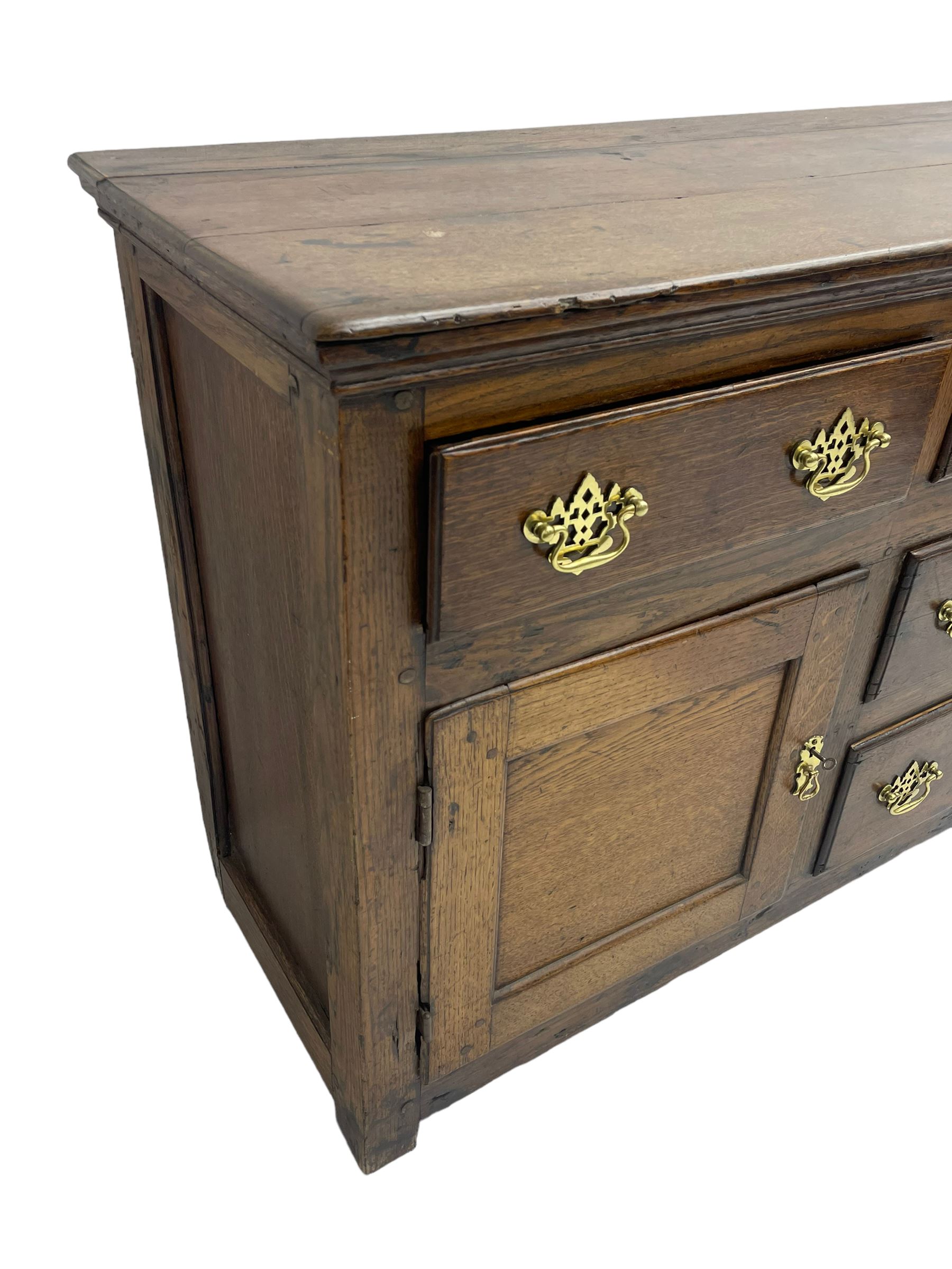George III country oak dresser base,  rectangular top over with three central drawers flanked by two drawers and two panelled cupboards, each with moulded fronts, on stile feet