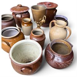 Large assorted collection of glazed stoneware jars and planters, with two lidded crocks, a brass urn and three decorative garden planters, including a pair of shell-form examples