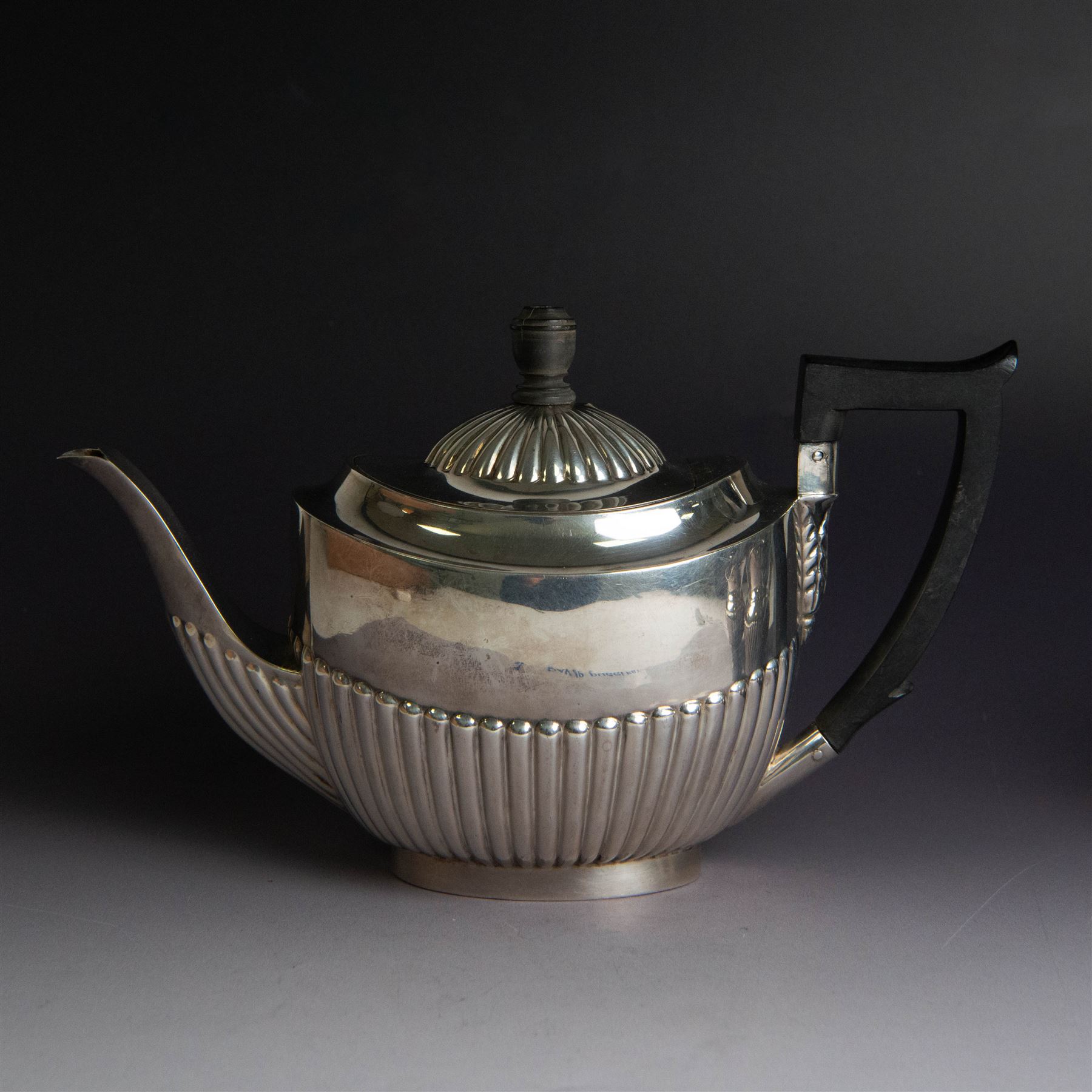 Victorian silver bachelors teapot, of part fluted oval form with ebonised wooden handle and finial, hallmarked Thomas Bradbury & Sons, London 1896, together with a Edwardian silver milk jug and open sucrier, of similar form with oblique gadrooned rims, hallmarked George Unite, Birmingham 1902 & 1906
