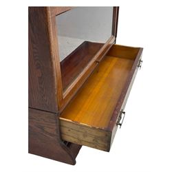 Early 20th century oak stacking library bookcase, four sections enclosed by hinged and sliding glazed doors, fitted with single drawer 