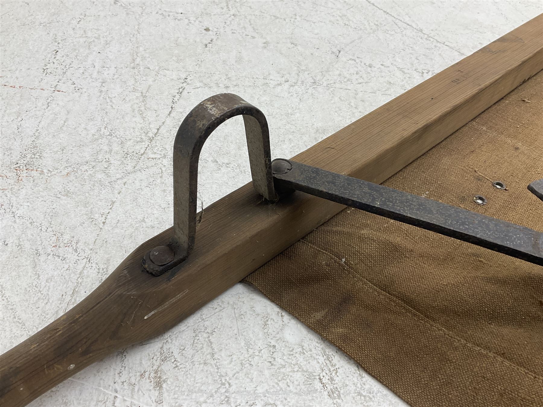 WW1 British casualty stretcher with iron mounted pitch pine sides and canvas base; stamped 'HL1917' and L7 with broad arrow in a triangle L236cm ( reputedly recovered from a barn at Bapaume on The Somme)