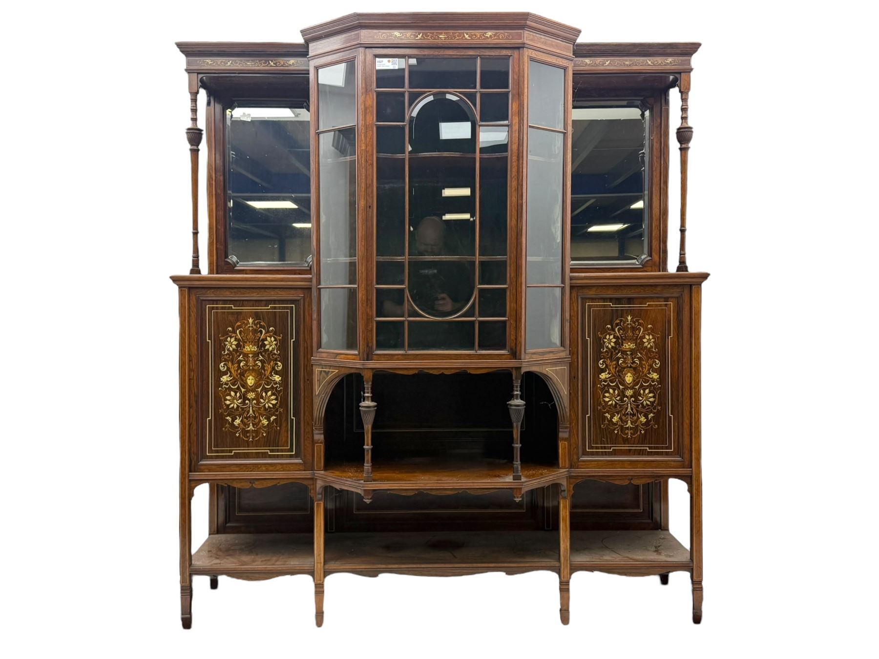 Victorian hardwood and inlaid display cabinet, central breakfront glazed display with astragal glazing and mirror back, flanked by mirrored alcoves with turned supports, below foliate and scrolling marquetry panels enclosing cupboard doors, shaped open shelves with turned supports beneath, on tapered and spade feet