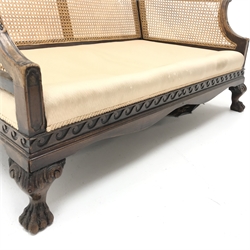  Early 20th century walnut two seat Bergere sofa, scrolled arms, acanthus carved cabriole leg with hairy paw feet, W134cm  
