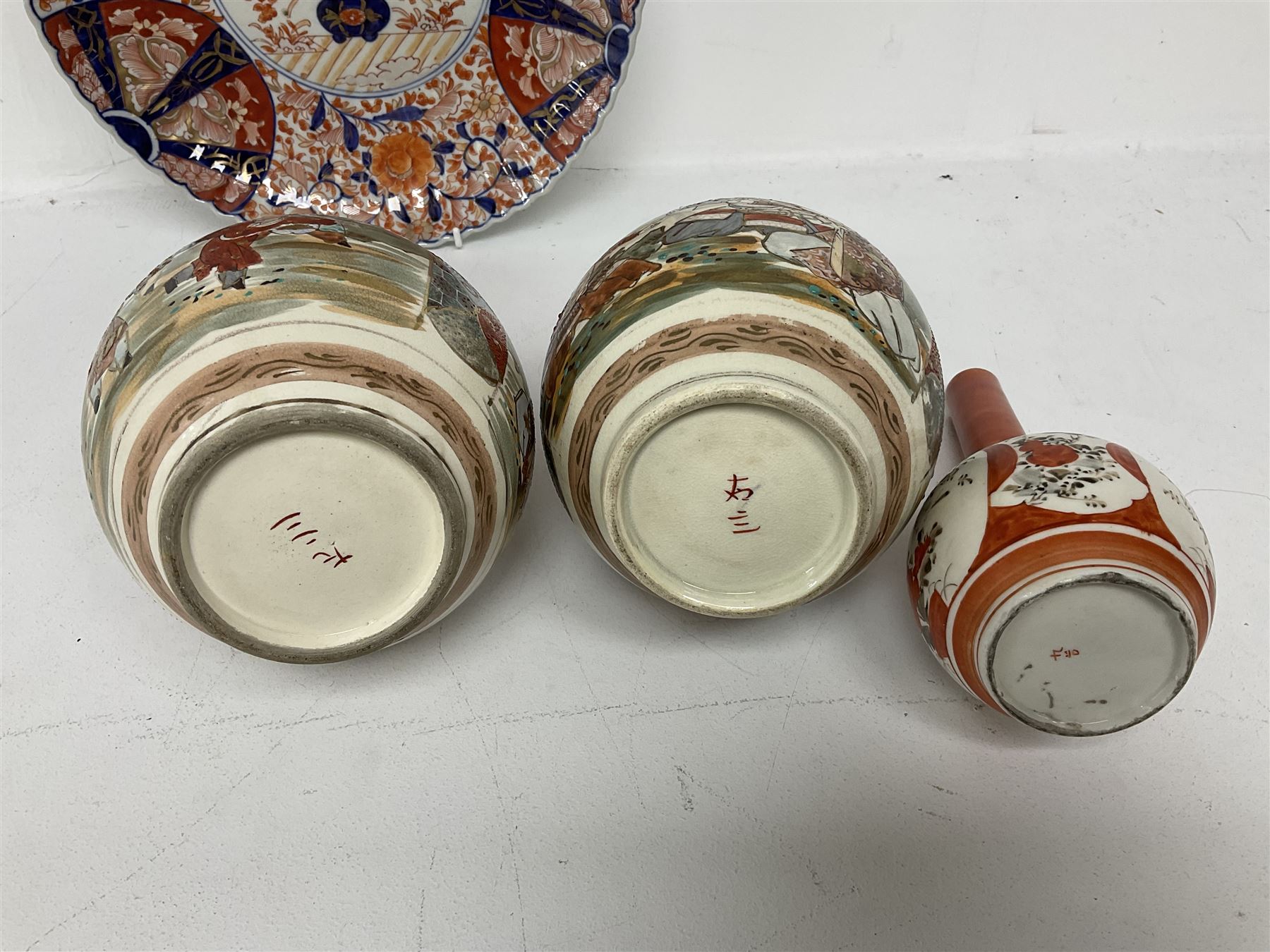 Collection of Japanese ceramics comprising pair of Satsuma vases decorated with panels depicting children and samurai figures, together with a Kutani vase painted with birds and flowers, all with painted character marks beneath, and an Imari plate, largest vase H31cm