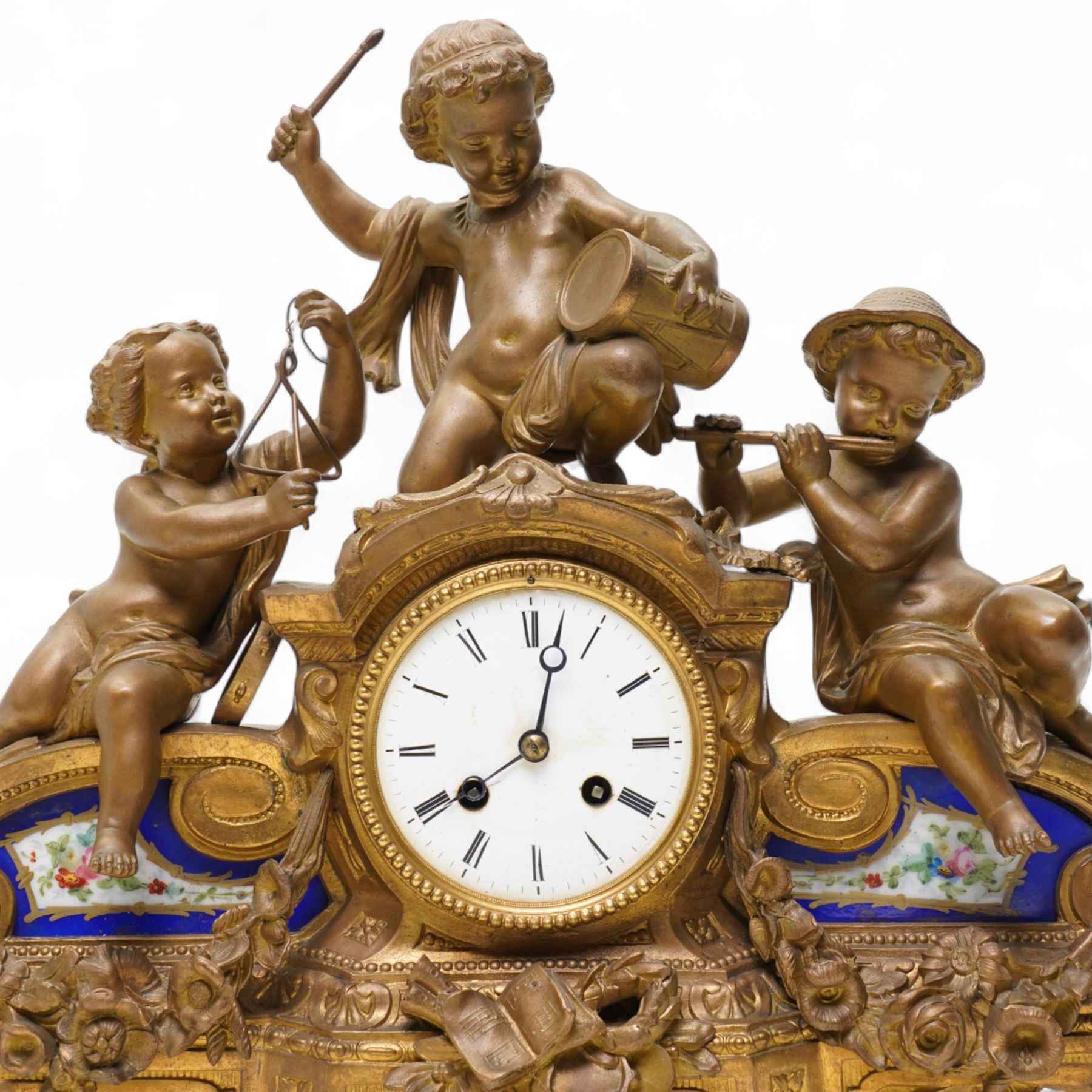 French-late 19th century gilt and spelter mantle clock, highly decorative case with two Sevres style porcelain panels to the front and surmounted with three figures of children playing musical instruments, white enamel dial with Roman numerals and steel moon hands, two train countwheel strike movement, striking the hours and half hours on a bell. With key and pendulum.    