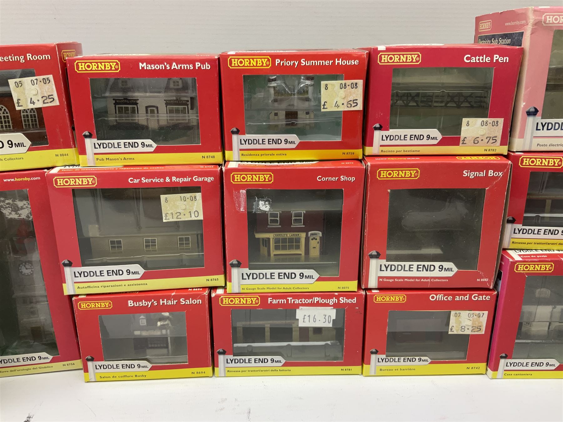 Hornby 'N' gauge - eighteen Lyddle End trackside buildings including The Old Toll House, Electricity Sub Station, Teesdale bakery, Mason's Arms Pub, various shops and hairdressers, farm buildings, Clock Tower etc; all boxed; and five Lyddle End blister pack cards of trackside accessories including Lamp Huts, Tractors, War memorial etc (23)