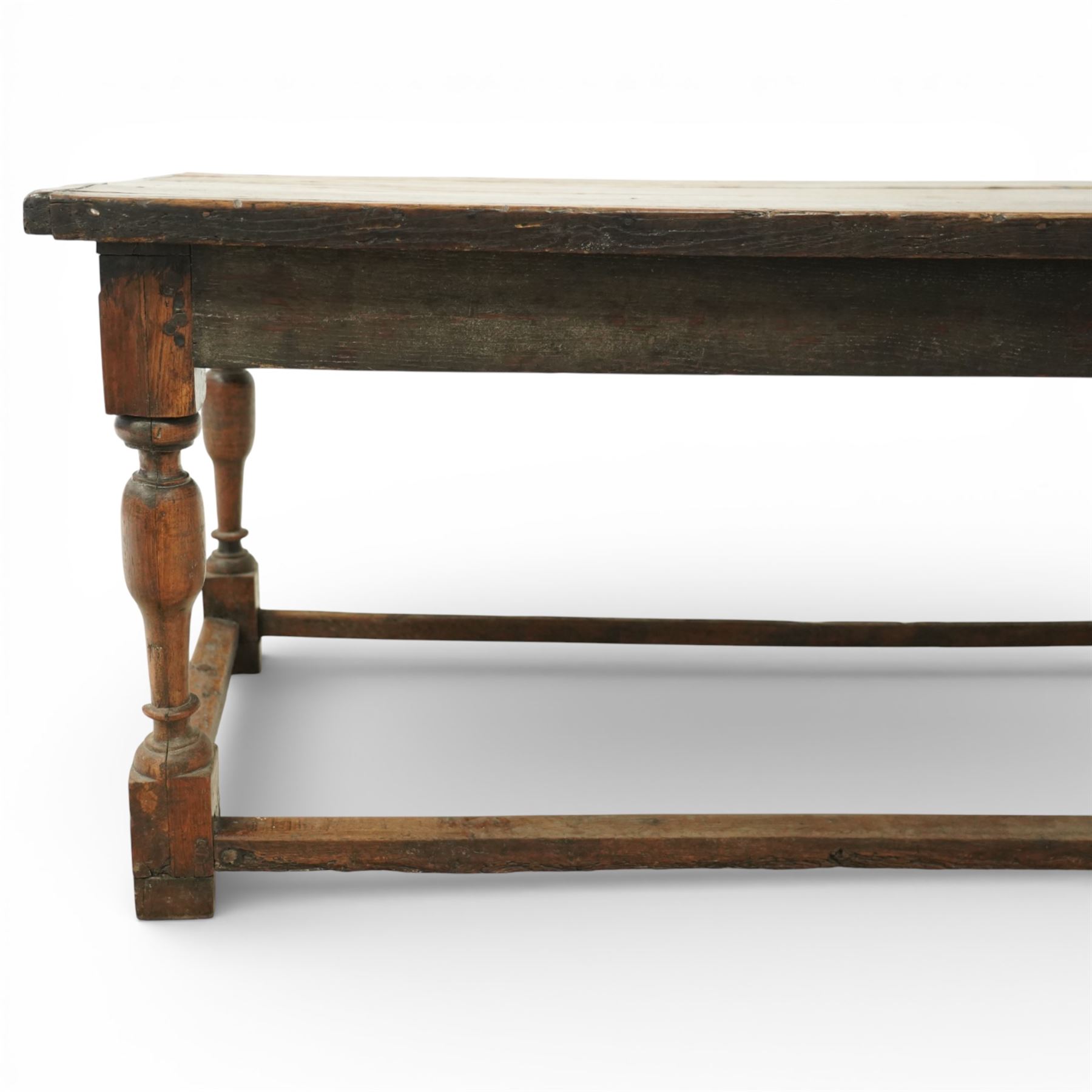 Late 17th to early 18th century oak joint refectory dining table, rectangular four plank top, raised on turned baluster legs, united by chamfered stretchers