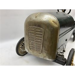 Mid 20th century pressed steel pedal car, the body painted in dark green fitted with pretend radiator to the bonnet, with spoked wheels and rubber tyres, the interior with pedals and steering wheel, L70cm