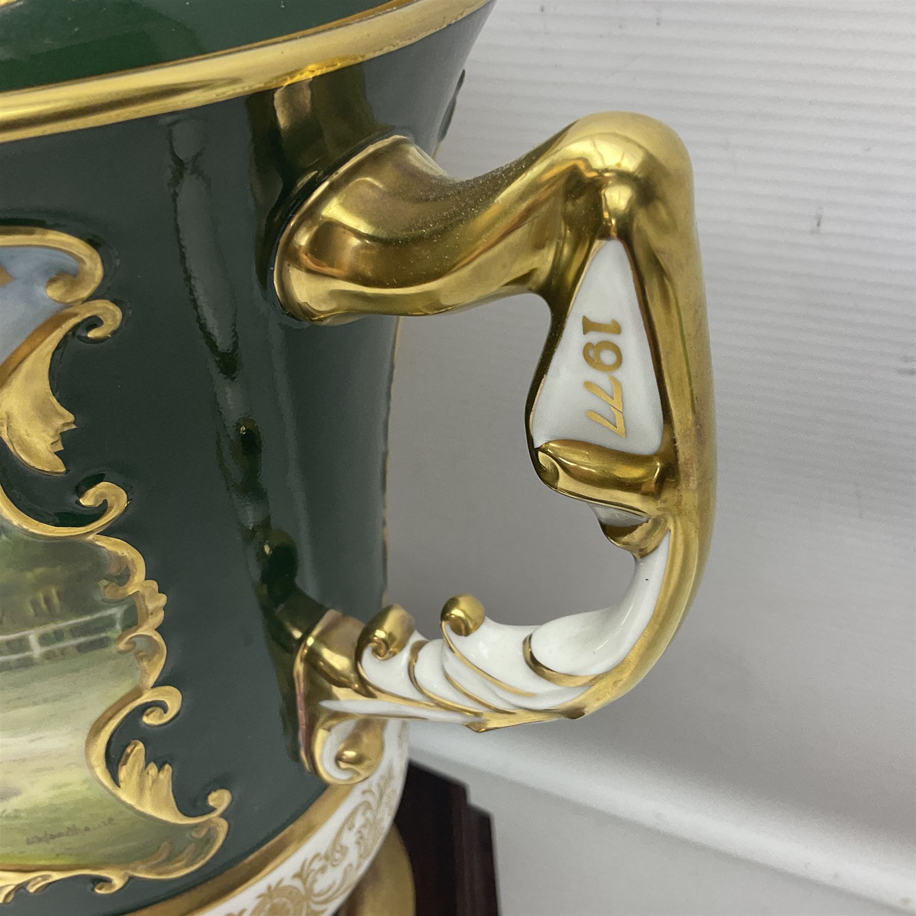 Aynsley twin handled racing cup and cover, to commemorate 'The Golden Jubilee of the Revival of The Yorkshire Cup', the handles inscribed '1927' and '1977', the green body painted by E. Woodhouse with Joe Childs up on Trimdon, the reverse with the winners, the domed cover with a Yorkshire rose finial, limited edition no. 4 of 50, on hexagonal wooden base with certificate, H34cm