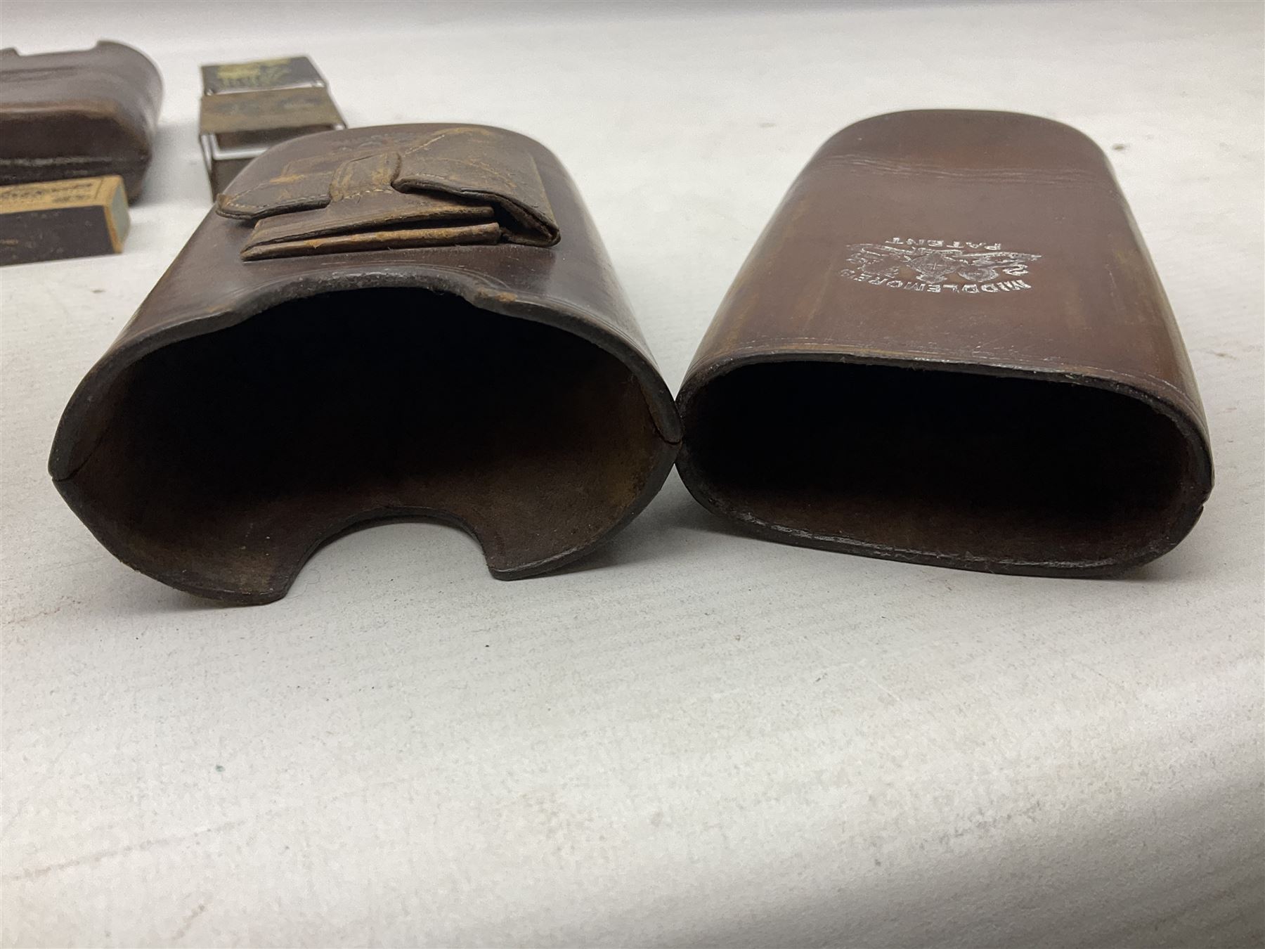 Victorian leather cigar protector with metal match striking plate on the end and internal spring to hold the cigars in place; expands for differing lengths of cigar, minimum L12.5cm; another similar leather cigar case marked Middlemore's Patent with attached vesta case and striker; three Bryant & Mays tin-late matchbox holders including 1935 Jubilee; and small box of matches (6)
