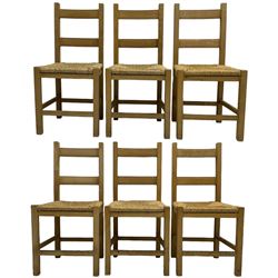 Set of six beech framed farmhouse design dining chairs, with rush seats, on square supports united by plain stretchers 