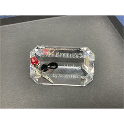 Swarovski Crystal Masquerade trilogy; 1999 Masquerade Pierrot, 2000 Columbine, 2001 Harlequin all with accompanying plaque, stand and original box, together with a glass display case with mirrored back and sides 