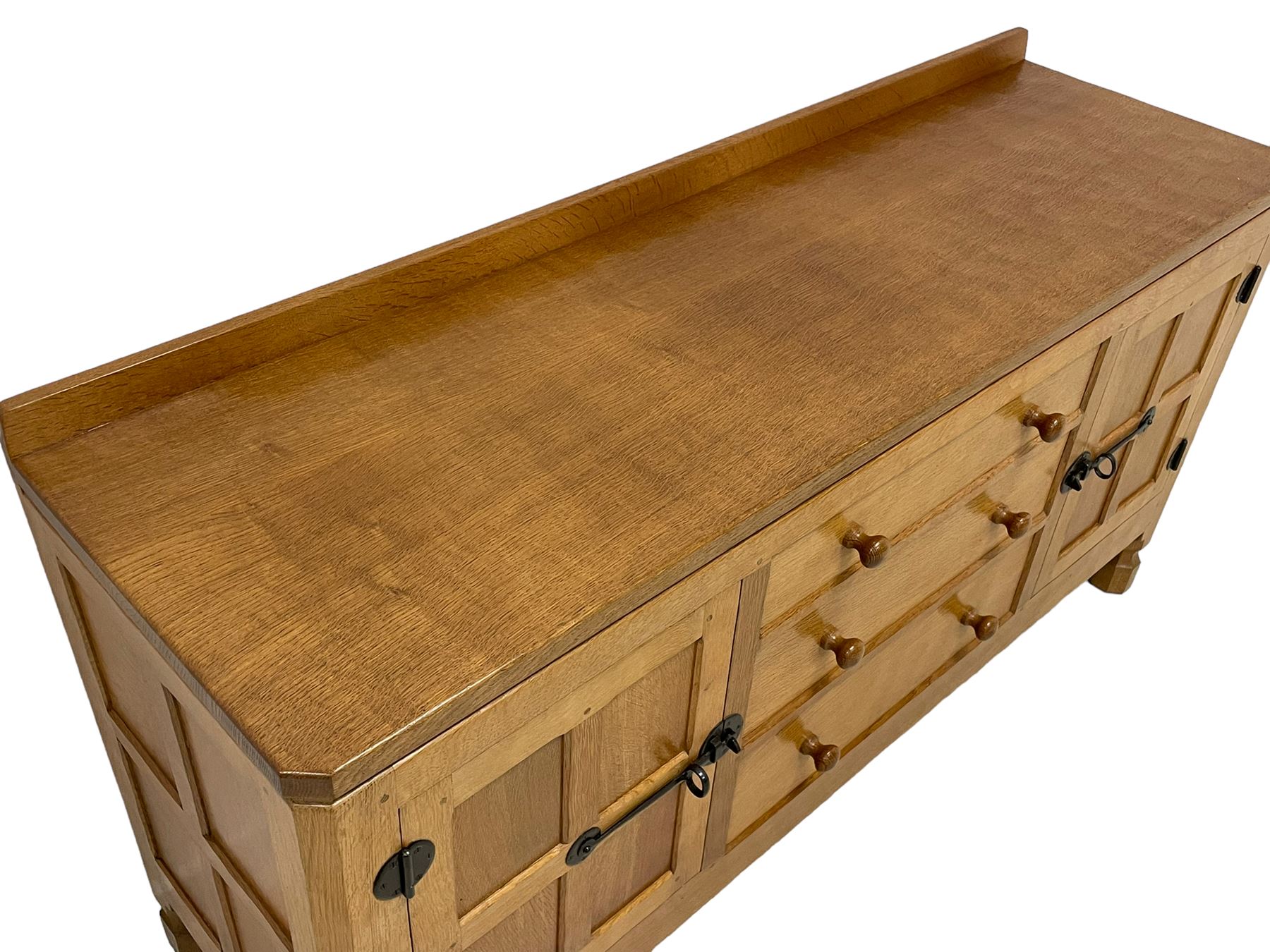 Mouseman - oak dresser, rectangular adzed top with raised back over three central drawers and two flanking cupboards, enclosed by panelled doors with wrought metal fixtures, the canted upright carved with mouse signature, on octagonal feet, by the workshop of Robert Thompson, Kilburn