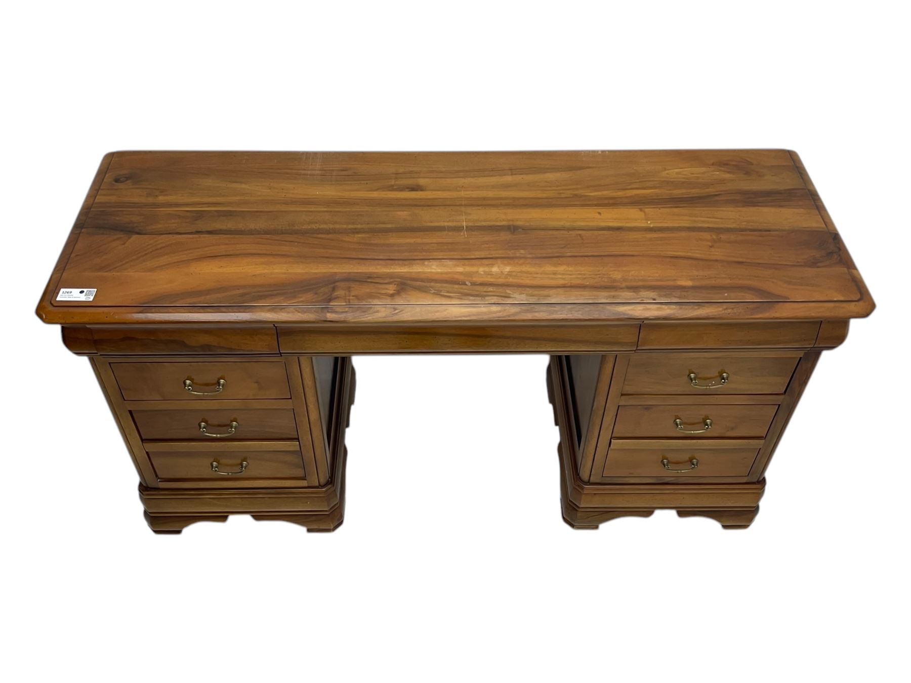 French cherry wood kneehole desk or dressing table, moulded rectangular top over twin pedestal bases each housing three drawers with brass-effect swing handles, resting on bracket feet