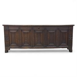 18th century oak five panel chest, with planked top with chamfered edges, hinged top enclosing two candle boxes, five fielded panels flanked by foliate carvings, raised on stile supports