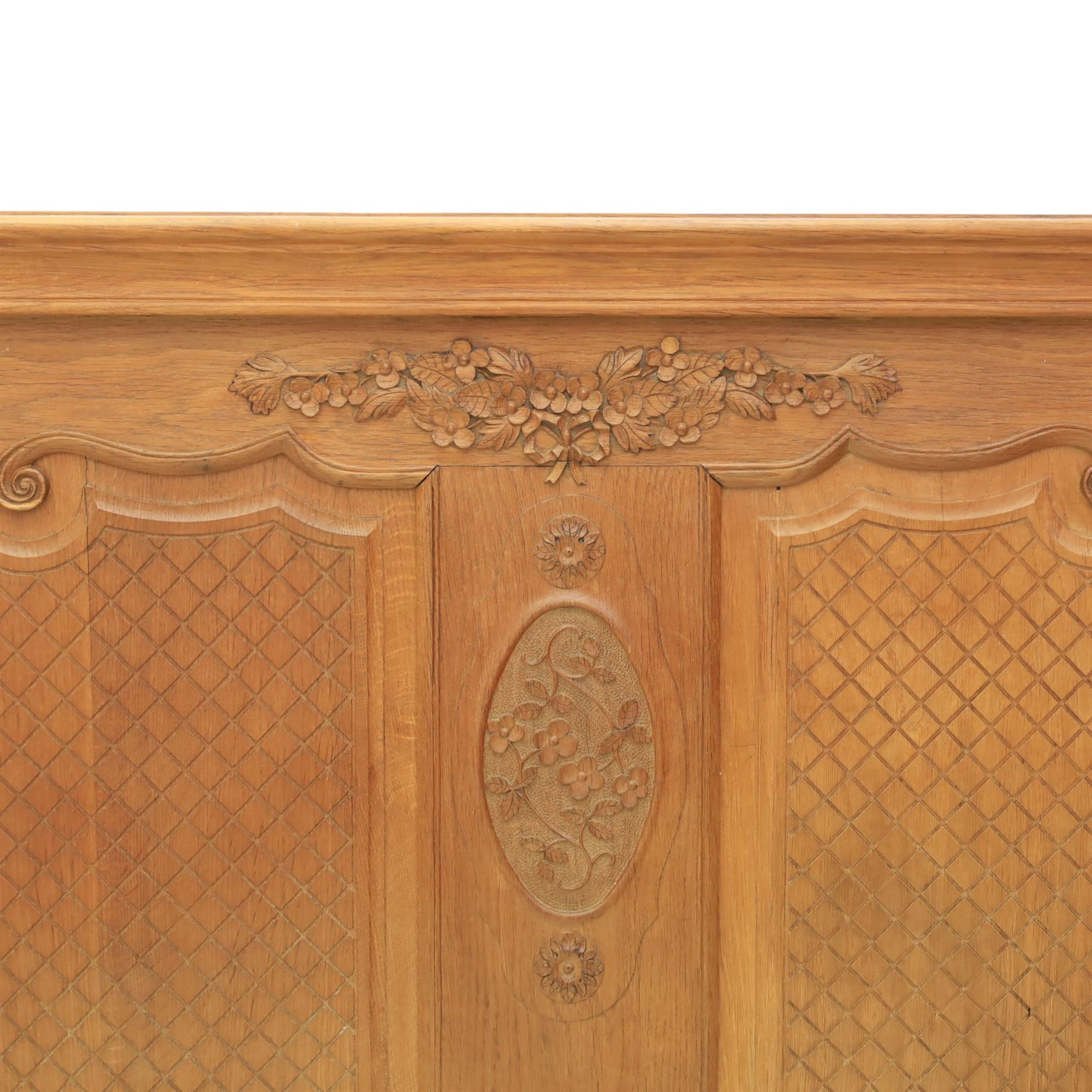 Early 20th century French oak double bedstead, the shaped and moulded headboard carved with central floral cartouche and scrolling foliage above lattice carved panels, the conforming footboard with pierced and carved decoration, shaped apron with foliate carving, raised upon cabriole supports