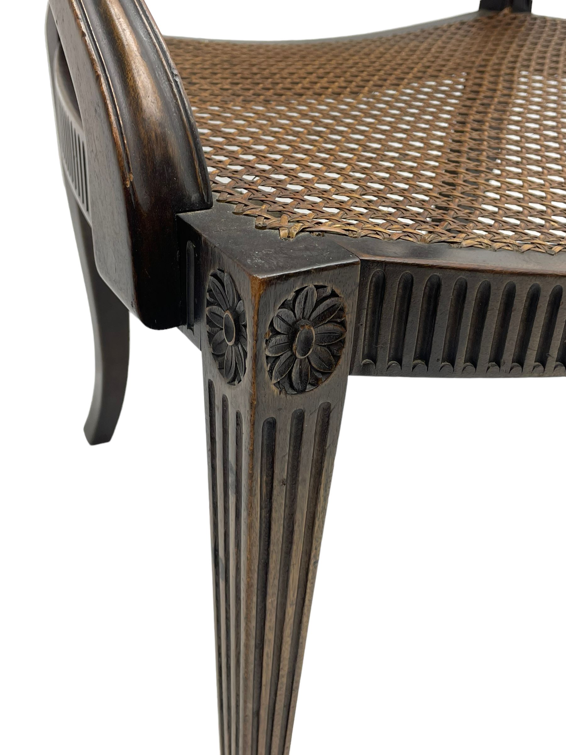 Mid-to late 20th century walnut Hepplewhite design elbow chair, circular cane back with pierced and carved central rosette, fluted frame with scrolling arms, cane seat raised on fluted rail and square tapering supports with spade feet