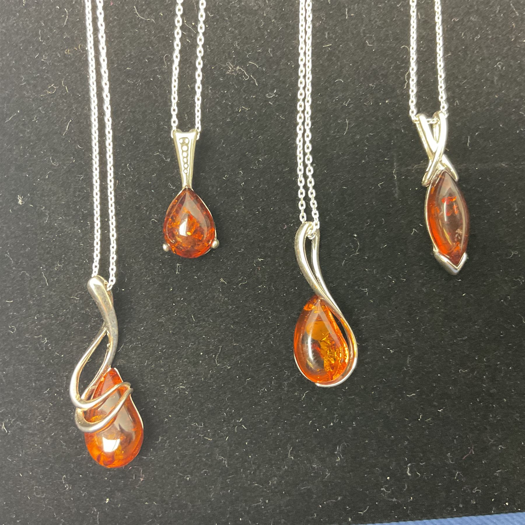 Seven silver Baltic amber pendant necklaces, including octopus and butterfly designs, all stamped 925 
