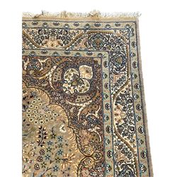 Persian Kashan pale green ground rug, the field and medallion decorated with tree of life surrounded by trailing leafy branches and flower head motifs, the guarded border decorated with repeating stylised plant and flower head motifs 