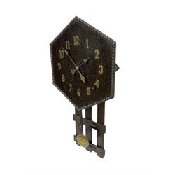1920’s Art deco drop dial wall clock - with an eight day spring driven timepiece movement, hexagon dial in dark oak with applied brass Arabic numerals and arrow shaped hands, open framework backboard, visible wooden pendulum with a brass faced bob.