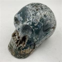 Carving of a skull in moss agate, H9cm, L12cm 