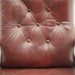 Late Victorian mahogany open armchair, arched cresting rail decorated with turned roundel, upholstered in buttoned burgundy leather, the upholstered arms on turned and lobe carved balustrade, turned and lobe carved front feet with brass and ceramic castors 